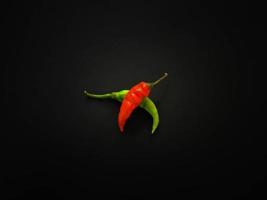 Natural green and red chilies on a dark background. Top view with food background, black stone table, copy space. photo