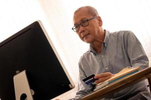 Asian businessman doing financial transactions by computer at the office room. photo