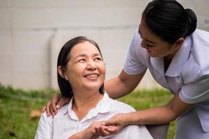 Beautiful nurse taking care of female patient at the hospital park photo