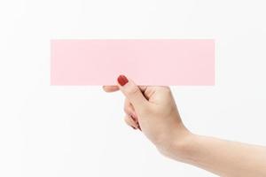 Close up women holding pink blank paper on white background. photo