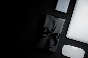 venta de lunes cibernético espacio libre para texto con mouse, computadora portátil, disco duro y caja de regalo sobre fondo negro. foto