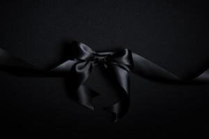 Top view of black ribbon on black background with free copy space for text. photo