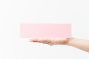 Close up women holding pink blank paper on white background. photo