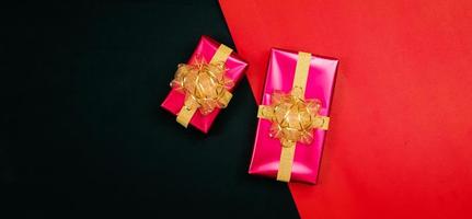 black gift box with black ribbons isolated on black background photo