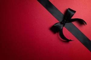 Top view of black ribbon on red background with free copy space for text. photo