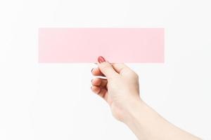 Close up women holding pink blank paper on white background. photo