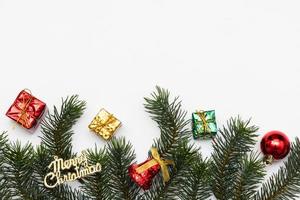 Top view of Christmas gift box red balls with spruce branches, pine cones, red berries and bell on white background. photo