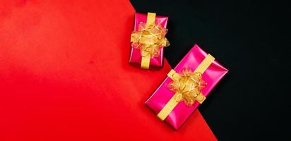 black gift box with black ribbons isolated on black background photo