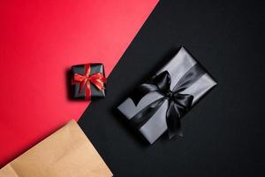 Top view of black gift box with red and black ribbons isolated on black background. photo