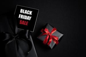 Top view of Black Friday Sale text with black gift box isolated on black background. photo