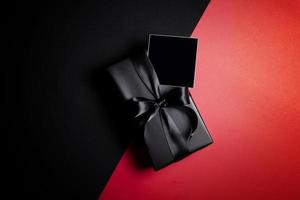 Top view of free space for text with black gift box isolated on black background. photo