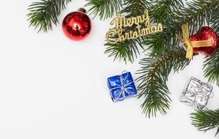 Top view of Christmas gift box red balls with spruce branches, pine cones, red berries and bell on white background. photo