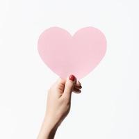 Close up women holding pink blank paper on white background Premium Photo