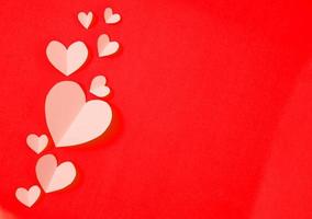 Paper elements in shape of heart flying on red paper background Premium Photo