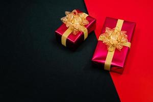 Top view of black gift box with red and black ribbons isolated on red and black background. Shopping concept boxing day and black Friday sale composition. photo