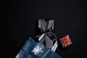 Top view of black gift box with red and black ribbons isolated on black background. photo