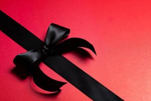 Top view of black ribbon on red background with free copy space for text. photo