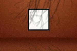 Minimal empty square white frame picture mock up hanging on wall background with leaves window. photo