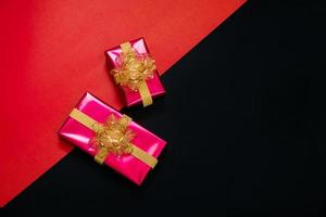 black gift box with black ribbons isolated on black background photo