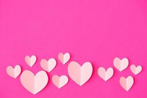 Shape of heart flying on pink paper background. photo