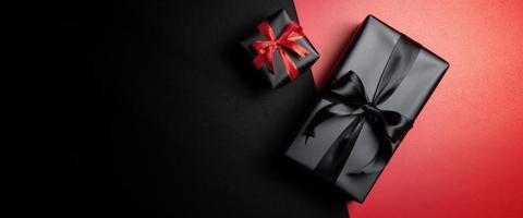 caja de regalo negra con cintas negras aisladas en fondo negro foto