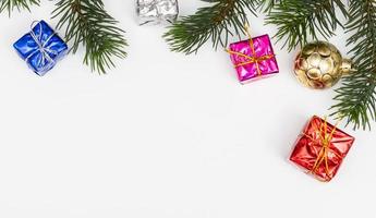 Top view of Christmas gift box red balls with spruce branches, pine cones, red berries and bell on white background. photo