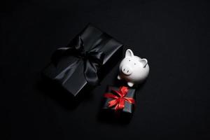 Top view of black gift box with red and black ribbons isolated on black background. photo