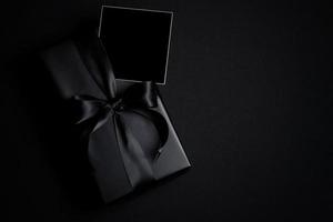 Top view of free space for text with black gift box isolated on black background. photo