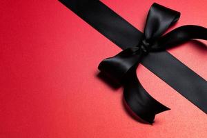 Top view of black ribbon on red background with free copy space for text. photo