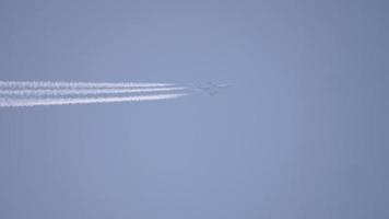 traînées dans le ciel bleu d'août. avion volant haut. video