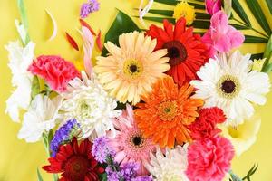 Fresh spring flowers frame tropical plant gerbera chrysanthemum colorful flower various and green leaves photo