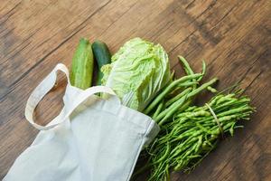 cero desperdicio usar menos plástico concepto verduras frescas orgánicas en bolsas de tela de algodón ecológico sobre mesa de madera foto