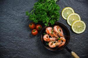 Seafood plate with shrimps prawns cooked on pan with herbs and spices photo