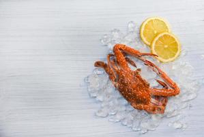 Seafood crab boiled cooked lemon and ice on white wooden background Blue Swimming Crab photo