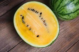 Yellow watermelon cut half on wooden, Closeup pile of sweet watermelon slices pieces fresh watermelon tropical summer fruit photo