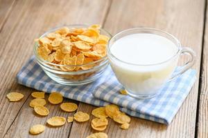 cornflakes bowl breakfast food and snack for healthy food concept, morning breakfast fresh whole grain cereal, cornflakes with milk on table food wooden background photo