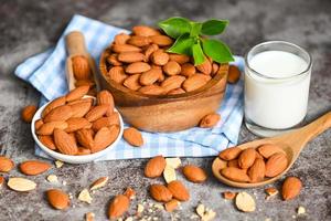 Almond milk and Almonds nuts on bowl background, Delicious sweet almonds on the table, roasted almond nut for healthy food and snack photo