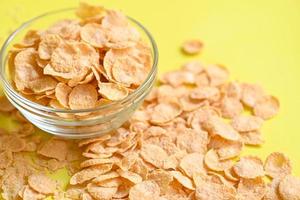 cornflakes bowl breakfast food and snack for healthy food concept, morning breakfast fresh whole grain cereal, cornflakes on yellow background photo