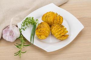 Baked potato on the plate and wooden background photo