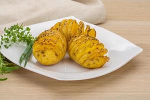 Baked potato on the plate and wooden background photo