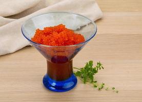 Red caviar in a bowl on wooden background photo