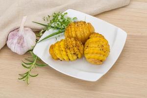 Baked potato on the plate and wooden background photo