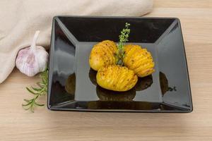 Baked potato on the plate and wooden background photo