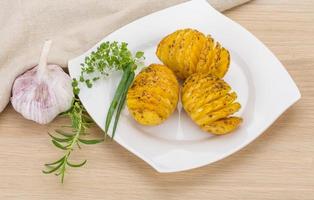 Baked potato on the plate and wooden background photo