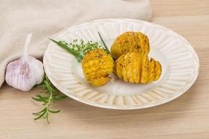 Baked potato on the plate and wooden background photo