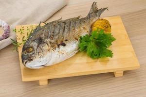 Grilled dorado on wooden board and wooden background photo