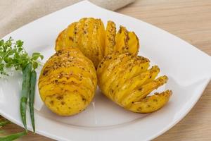 Baked potato on the plate and wooden background photo