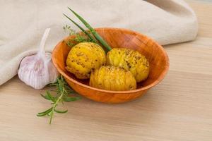 Baked potato in a bowl on wooden background photo