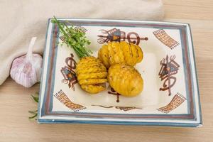 patata al horno en el plato y fondo de madera foto