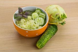 Kohlrabi salad in a bowl on wooden background photo